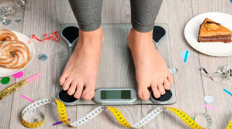 фото: зважування на вазі, тістечка на тарілці – ризик ожиріння