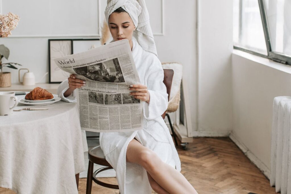 фото: жінка зранку читає газету – ранкові ритуали