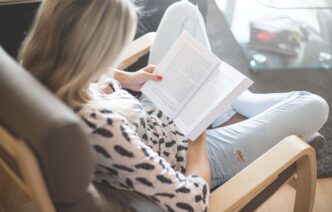 фото: женщина читает книгу в кресле – легкие и интересные книги
