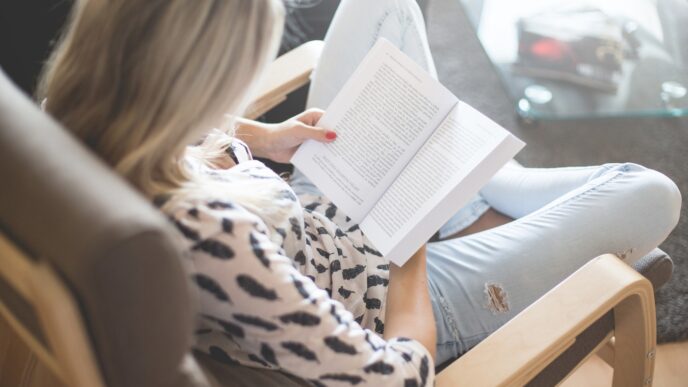 фото: женщина читает книгу в кресле – легкие и интересные книги