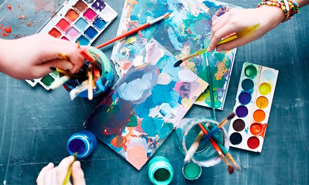 фото: фарби та малюнки, пензлики у руках – арттерапія