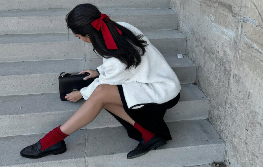 фото: жінка сидить на сходах у білому піджаку з яскравими аксесуарами – яскраві кольори