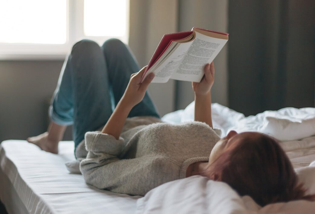 фото: дівчина в ліжку читає книгу – книги для осіннього читання