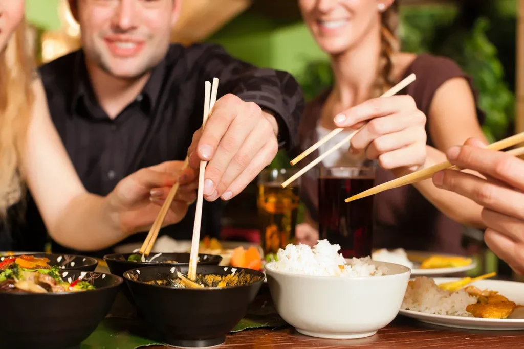 фото: люди їдять паличками азійську їжу – етикет
