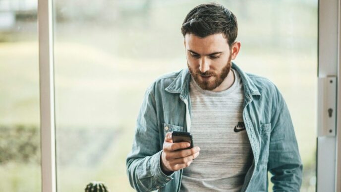 фото: чоловік дивиться у смартфон – технозвички