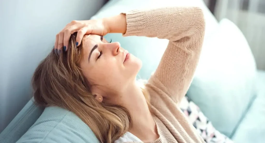 фото: жінка у стресі сидить на дивані – вплив хронічного стресу на тіло