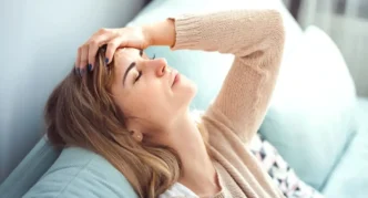 фото: жінка у стресі сидить на дивані – вплив хронічного стресу на тіло