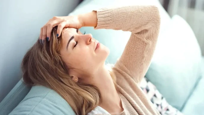 фото: жінка у стресі сидить на дивані – вплив хронічного стресу на тіло