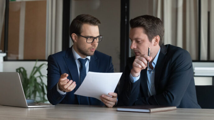 фото: чоловіки сидять за робочим столом – як управляти емоціями під час конфліктів