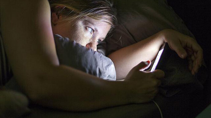 людина в ліжку зі смартфоном - вплив Instagram та Facebook на сон