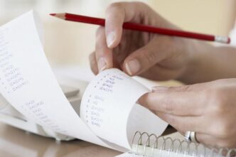 фото: людина рахує касові чеки – як збільшити середній чек у бізнесі