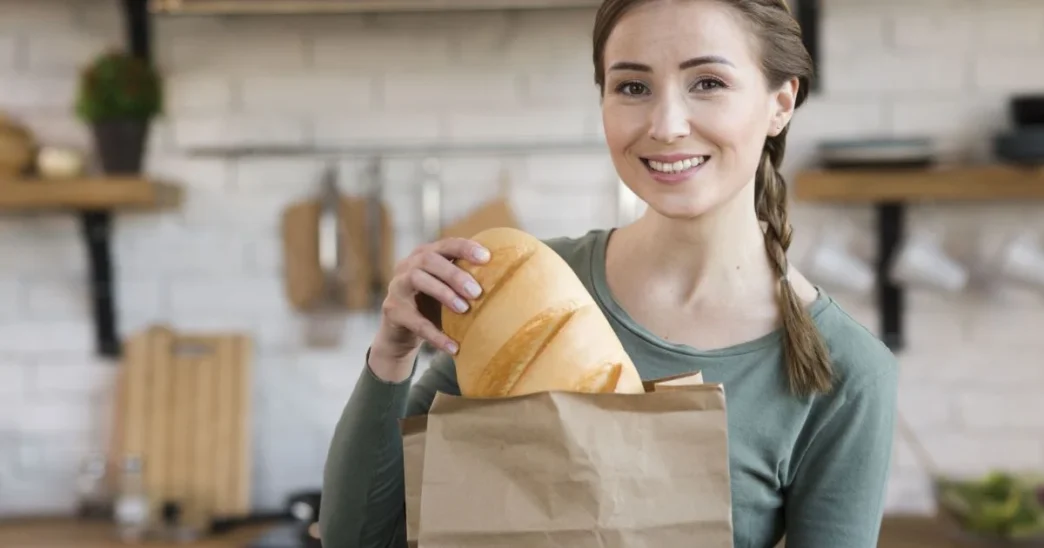 фото: жінка з хлібом на кухні - як хліб впливає на схуднення