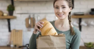 фото: жінка з хлібом на кухні - як хліб впливає на схуднення