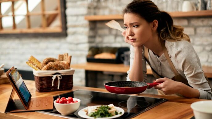 фото: задумана жінка зі сковорідкою на кухні - швидкі рецепти на час блекауту