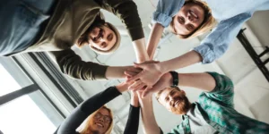 фото: усміхнена команда бізнесу, яка піднімає руки разом – ілюстрація командної роботи та ефективної співпраці