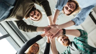 фото: усміхнена команда бізнесу, яка піднімає руки разом – ілюстрація командної роботи та ефективної співпраці