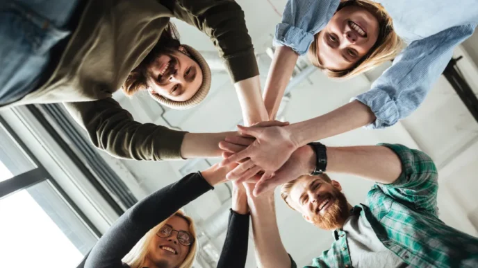 фото: усміхнена команда бізнесу, яка піднімає руки разом – ілюстрація командної роботи та ефективної співпраці