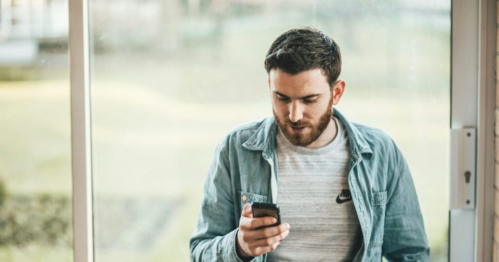 фото: чоловік зі смартфоном в руках –