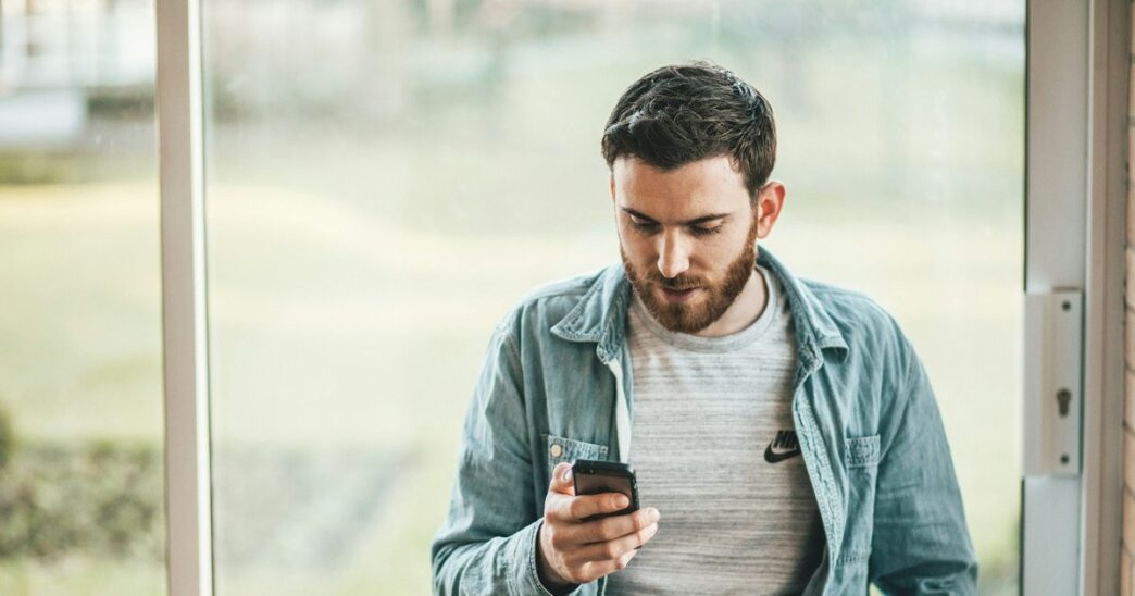 фото: чоловік зі смартфоном в руках –