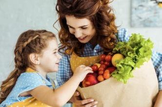 фото: жінка з дитиною тримає пакет корисних продуктів